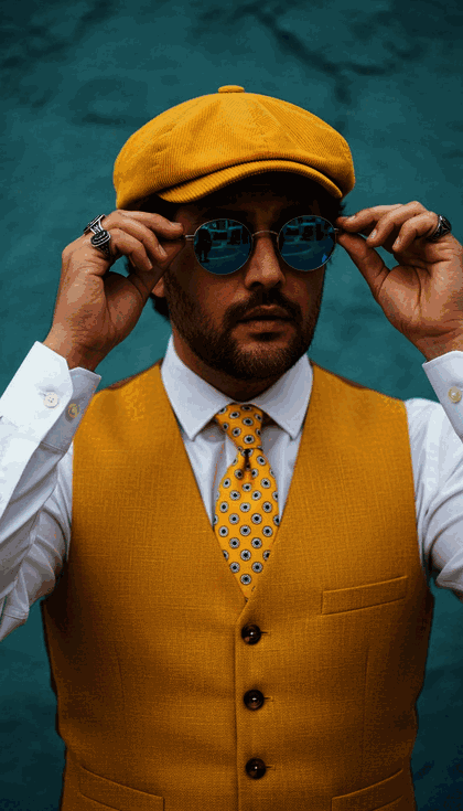 ژست خاص، لباس زرد، عینک آبی، پس‌زمینه فیروزه‌ای